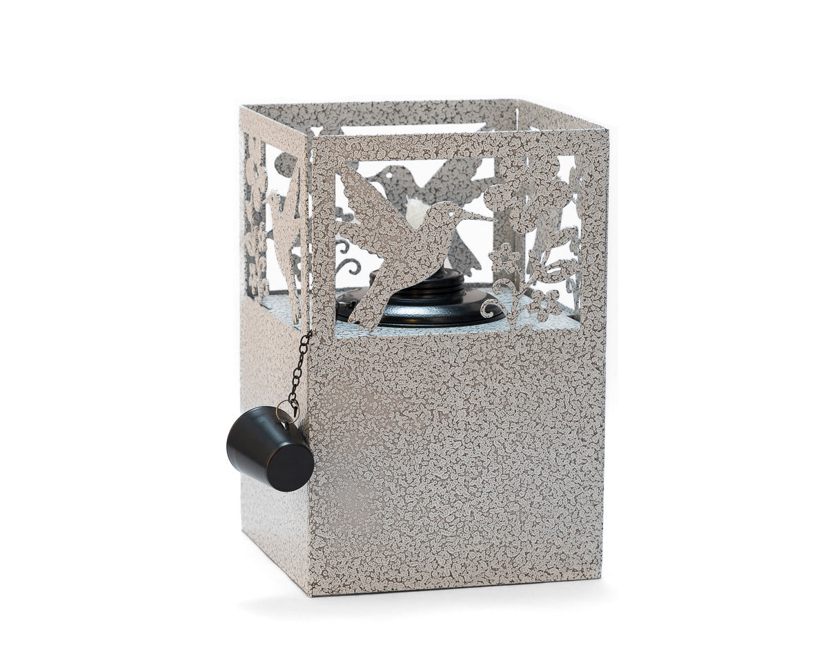 Rustic metal hummingbird tiki torch with floral cutout design, handcrafted outdoor lantern for garden, patio, or yard lighting.