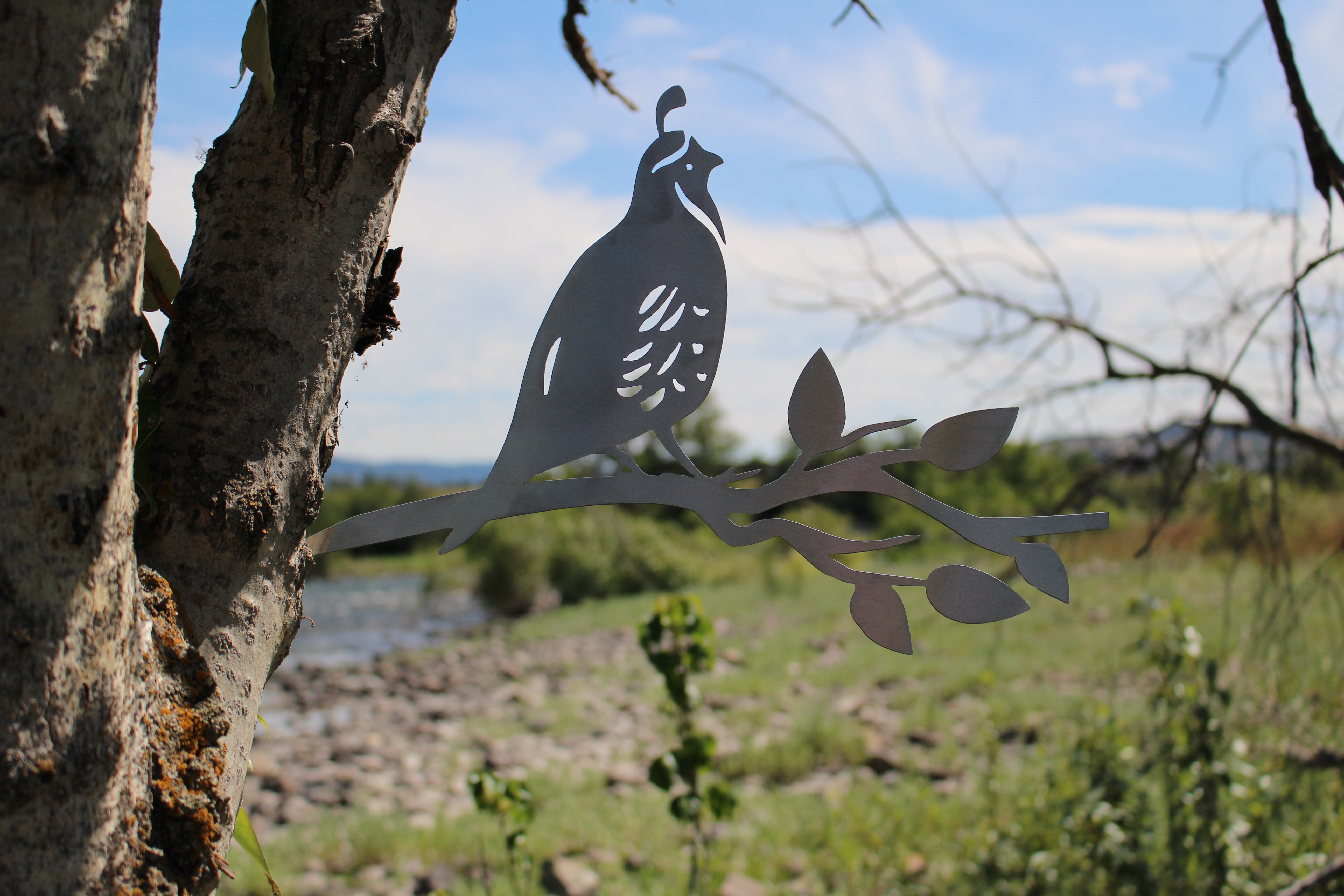 Metal quail tree stake on branch, rustic steel garden decoration for outdoor yard or flower bed