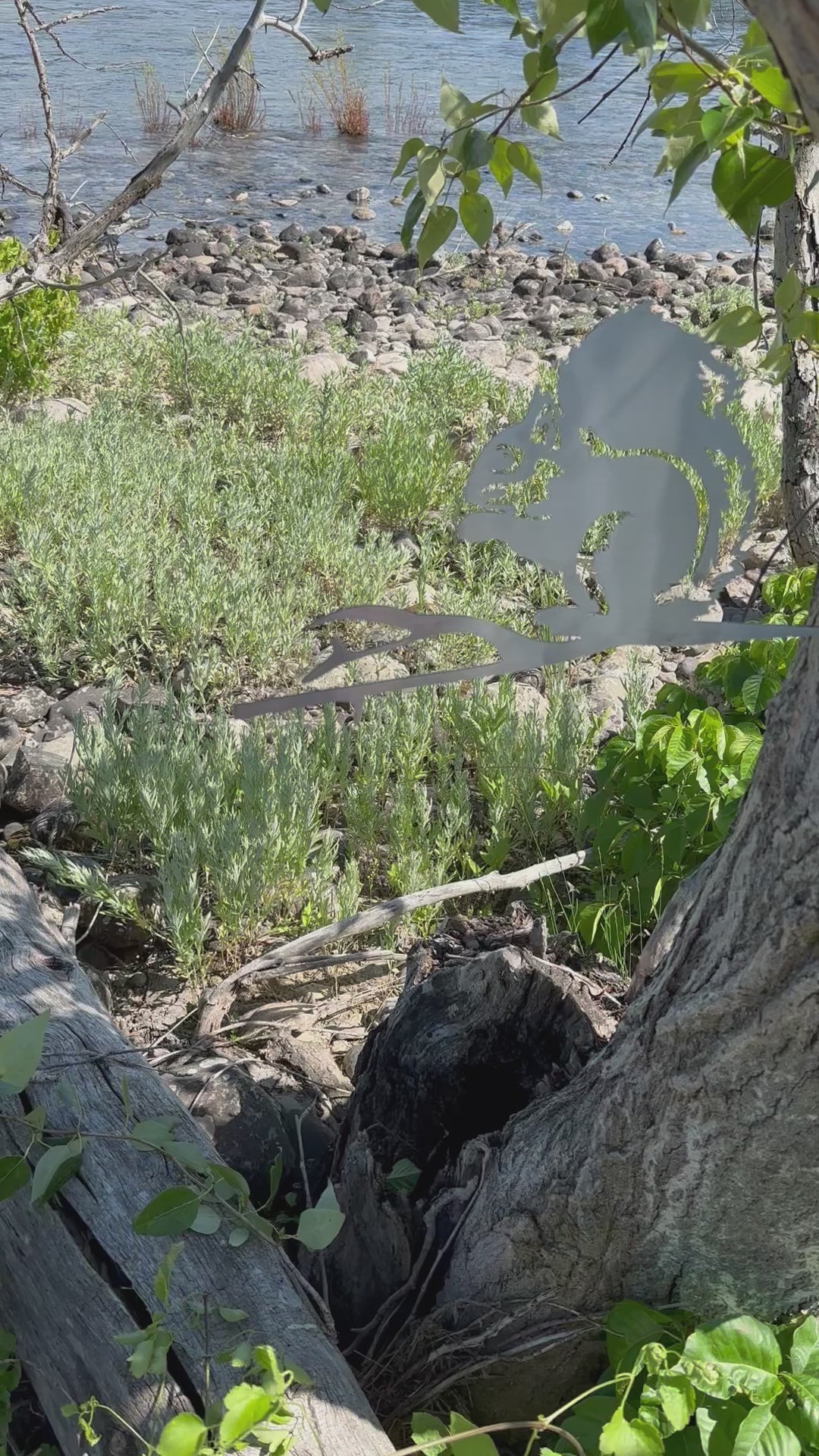 Load video: Metal squirrel tree stake on branch, rustic steel garden decoration for outdoor yard or flower bed